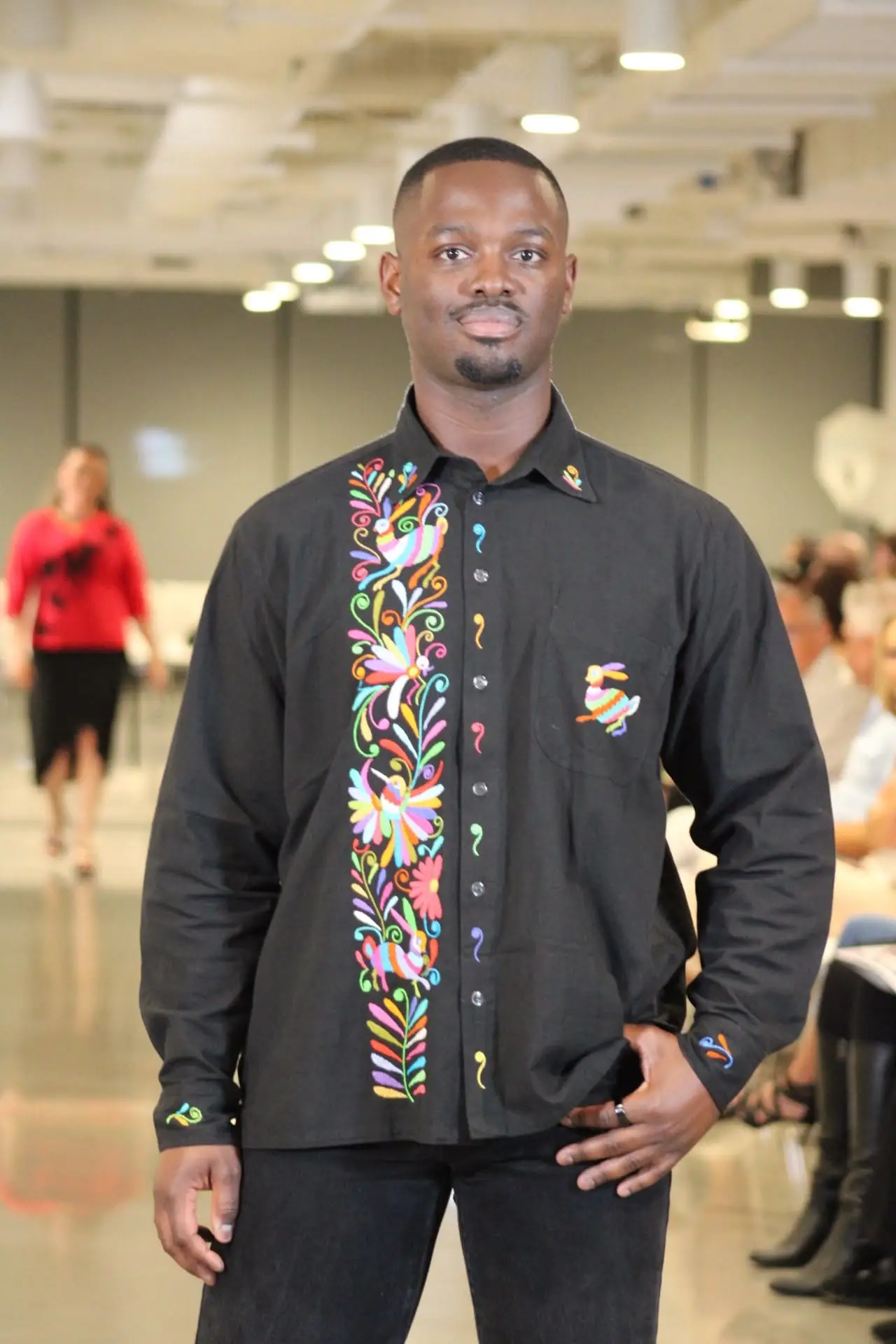 Man wearing the hand-embroidered black Tenango men's shirt with pastel florals.